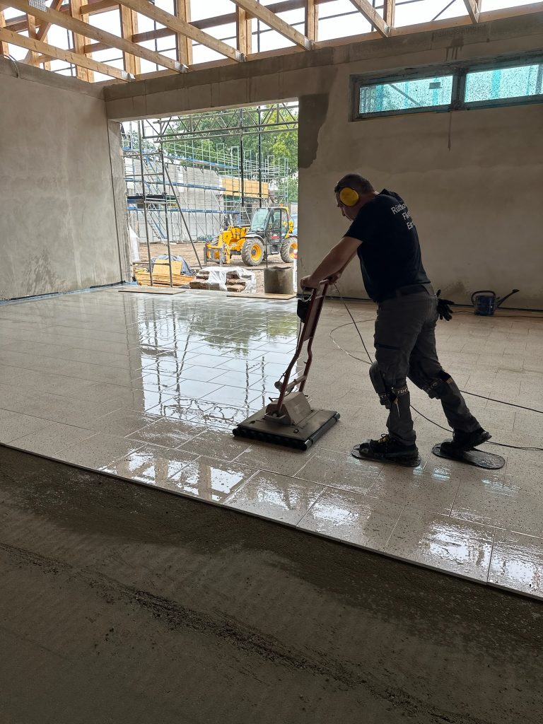 Ein glänzender Boden und eine Person, die ihn reinigt.