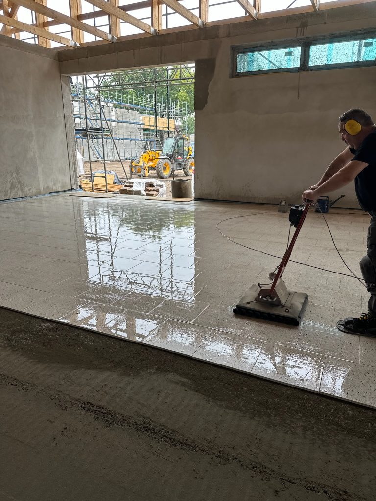 Ein glänzender Boden und eine Person, die ihn reinigt.