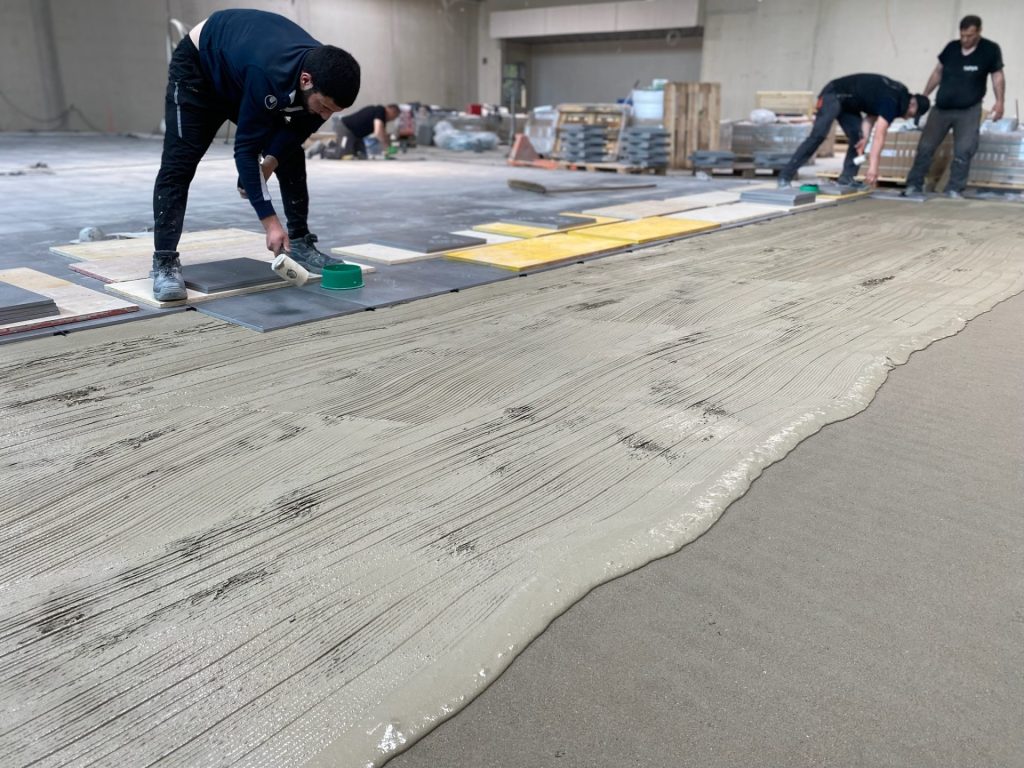 Drei Personen arbeiten auf einem Boden